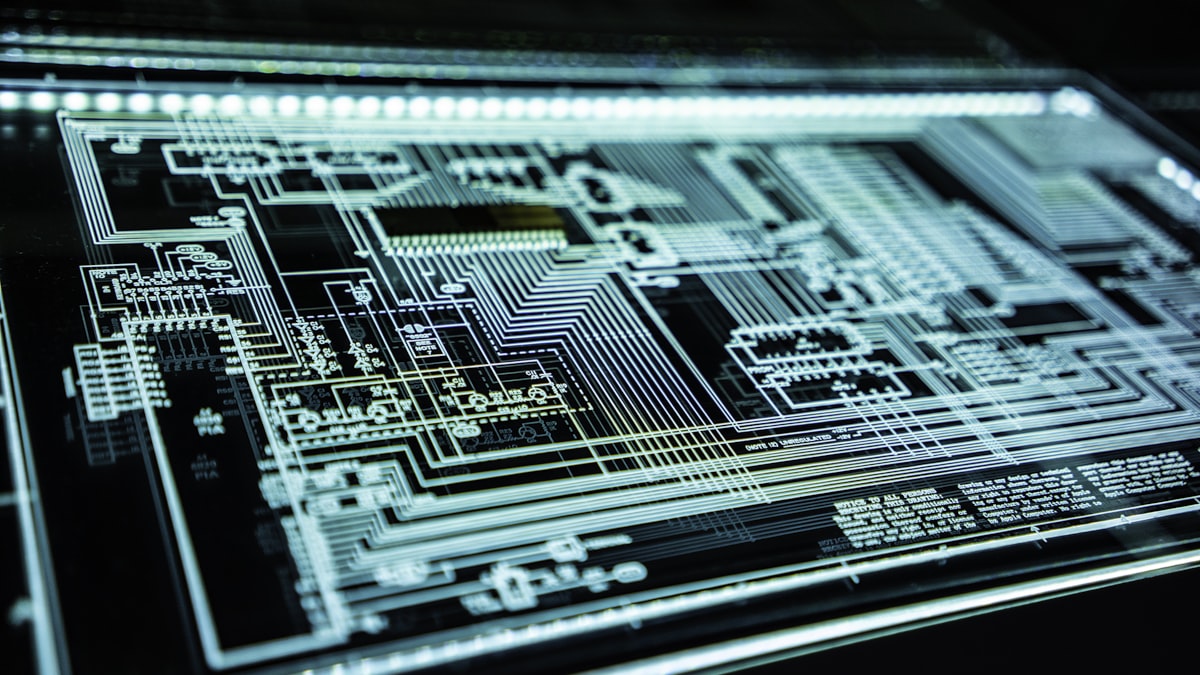 Close-up of a circuit board with illuminated traces running between components